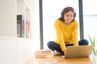 Bilgisayar ve mobil aygıt kullanan genç kolaj öğrencisi çevrimiçi eğitim, çevrimiçi eğitim veya kendi kendine öğrenim kavramı.