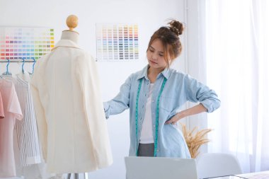 Moda tasarımcısı stüdyoda çalışıyor, çizim kesme, dikiş elbise