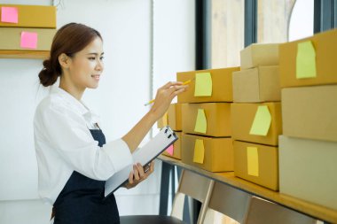 Genç iş kadını, küçük işletmelerdeki envanterleri kontrol etmeye başlar. İş kadını, depodaki envanterleri kontrol eder. Mağaza teftişi.