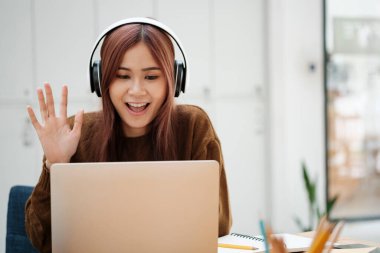 Genç bayan öğrenci evde okuyor. Bilgisayarı kullanması ve internetten öğrenmesi..