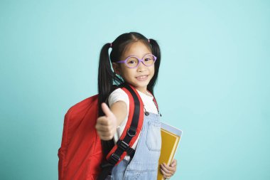 Kid students girl going to school, i like school. Smiling pose for camera on sky blue studio background. school concept.