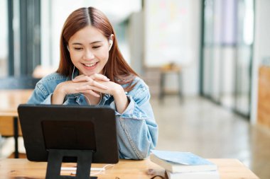 Genç bayan öğrenci evde ders çalışıyor. Bilgisayarı kullanması ve internetten öğrenmesi..