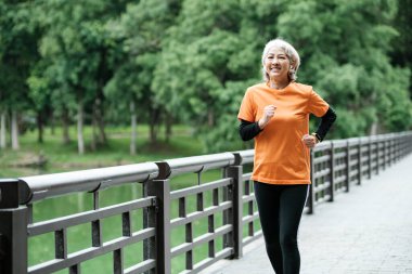 Atletik Asyalı son sınıf öğrencisi sabah parkta koşuyor..