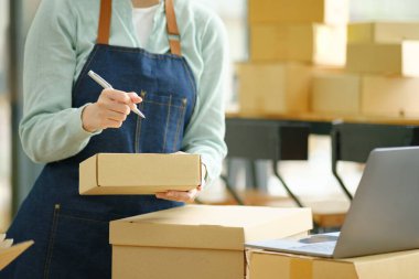 Çevrimiçi küçük işletme sahibi, müşteri, nakliyat ve lojistik, tüccar ve satıcı, işletme sahibi veya KME 'ye çevrimiçi alışveriş için paket kutusuna adres yazıyor.