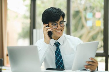 Genç girişimci profesyonel bir müşteriyle konuşuyor, dizüstü bilgisayardaki yatırım pazarlama verilerini planlıyor ve analiz ediyor..