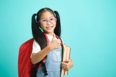 Kid students girl going to school, i like school. Smiling pose for camera on sky blue studio background. school concept.