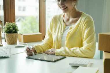 Küçük işletmeler kuran KOBİ 'li kadın girişimciler, müşterilerle sohbet ederek kutuları paketlemek, müşterilere satmak, iş fikirlerini çevrimiçi olarak satmak için çevrimiçi siparişler alıyorlar..