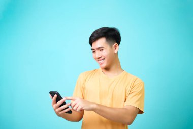 Young asian men wearing casual clothes smiling to using the phone. communication concepts.