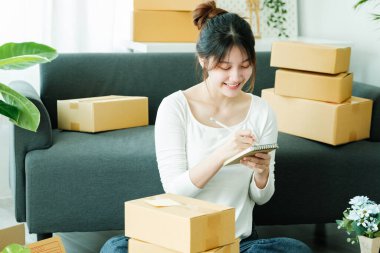 Çevrimiçi küçük işletme sahibi, müşteri, nakliyat ve lojistik, tüccar ve satıcı, işletme sahibi veya KME 'ye çevrimiçi alışveriş için paket kutusuna adres yazıyor.