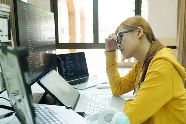 Young woman covering her face with the stress of work coding and programming software. frustrated on her work and out of control..