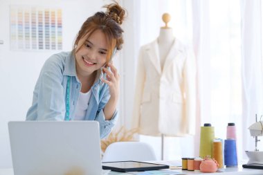 Moda tasarımcısı stüdyoda çalışıyor, çizim kesme, dikiş elbise