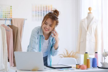 Moda tasarımcısı stüdyoda çalışıyor, çizim kesme, dikiş elbise