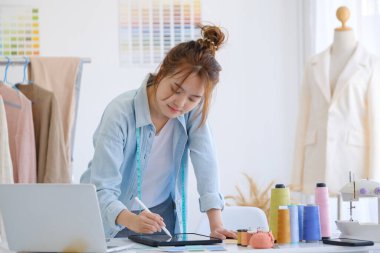 Moda tasarımcısı stüdyoda çalışıyor, çizim kesme, dikiş elbise