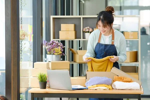 Asian Female Clothes Shop Owner Folding Shirt Packing Cardboard Parcel — Stok fotoğraf