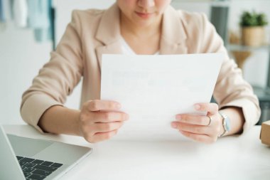 Young asian female freelan sit reading report on paper in online clothing store.Work at home concept. work from home.