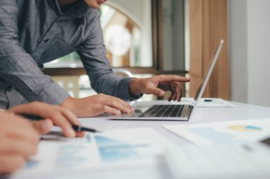 Close up asisan businessman teamwork meeting and discussing the investment data and report graph on laptop Teamwork meeting working concept.