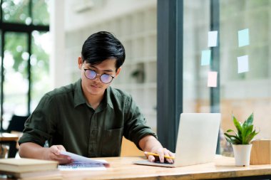 Smiling asian business man online working on laptop at home office. Young boy asian student or remote teacher using computer online studying, virtual training, watching online education webinar at