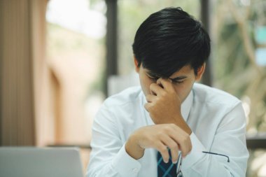 Businessman covering her face with both hands with the stress of work, frustrated on her work and out of control.