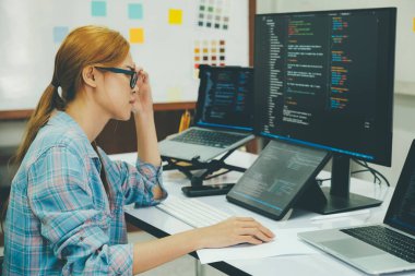 Young woman covering her face with the stress of work coding and programming software. frustrated on her work and out of control..