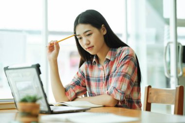Young asian woman student study at offsite. Her using laptop and learning online.