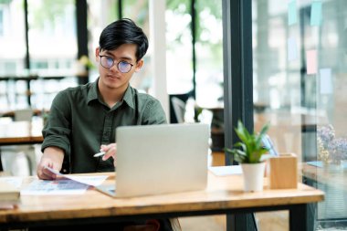 Young asian Startup Businessman planning and analyse investment marketing data.