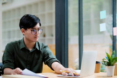 Young asian Startup Businessman planning and analyse investment marketing data.