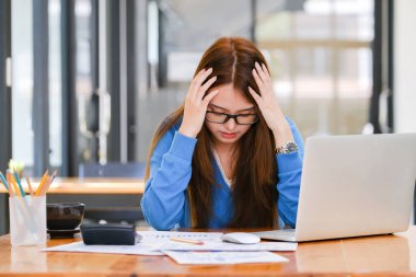 Businesswoman covering her face with both hands with the stress of work, frustrated on her work and out of control.