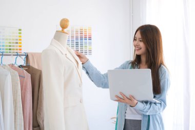 Moda tasarımcısı stüdyoda çalışıyor, çizim kesme, dikiş elbise