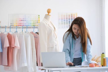 Moda tasarımcısı stüdyoda çalışıyor, çizim kesme, dikiş elbise
