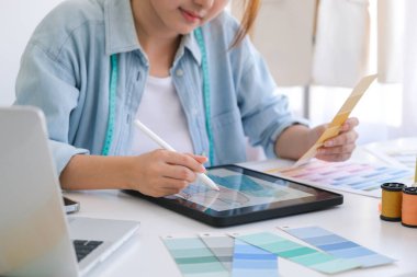 Moda tasarımcısı stüdyoda çalışıyor, çizim kesme, dikiş elbise