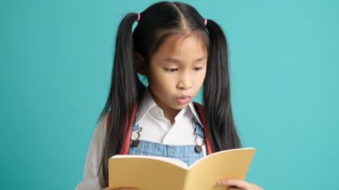 Close-up kid students girl smiling holding book, going to school. school concept. School girl upset at camera. High quality 4k footage