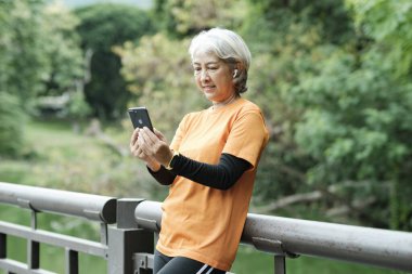 Happy senior woman taking selfie photo while before running in park. Concept of a healthy lifestyle on retirement. health concept.