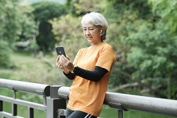 Happy senior woman taking selfie photo while before running in park. Concept of a healthy lifestyle on retirement. health concept.