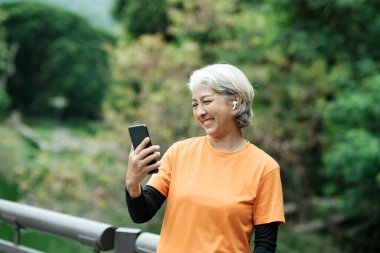 Happy senior woman taking selfie photo while before running in park. Concept of a healthy lifestyle on retirement. health concept.