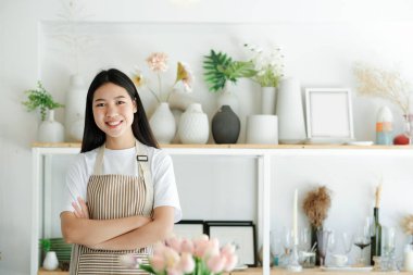 Kameraya gülümseyen, kendinden emin Asyalı genç bir kadının portresi..