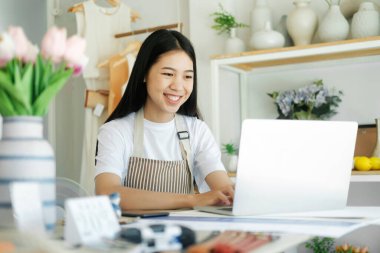 Young asian businesswoman excited by good news celebrate success or happy pose on laptop. Store house inspection.