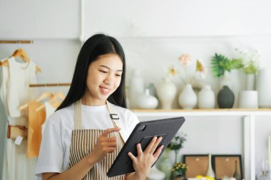 Young asian businesswoman excited by good news celebrate success or happy pose on laptop. Store house inspection.