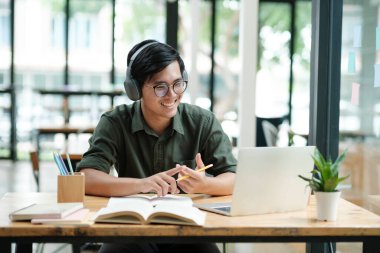 Young Asian man excited by good news celebrate success or happy pose with laptop.