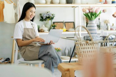 Genç iş adamı dizüstü bilgisayarda harika haberler okuduğu için çok heyecanlı. Seramik ürün satış odası. İş konsepti..