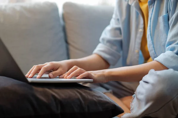 집에서 컴퓨터를 사용하여 공부하고 일하는 여성들의 여자들은 집에서 소파에 앉아서 — 스톡 사진