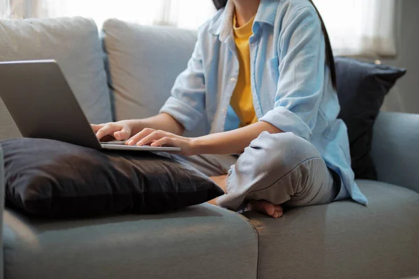 在家里工作和学习使用笔记本电脑的妇女的近况 在家里坐在沙发上工作 使用笔记本电脑研究的女性 靠近点教育和在线学习概念 — 图库照片