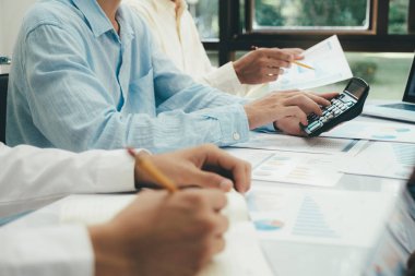 Başlangıçta Asya iş ekibi çalışması bilgisayar dizüstü bilgisayarındaki yatırım pazarlama verilerini analiz eder ve hesap makinesi ve finans toplantısı kullanır.