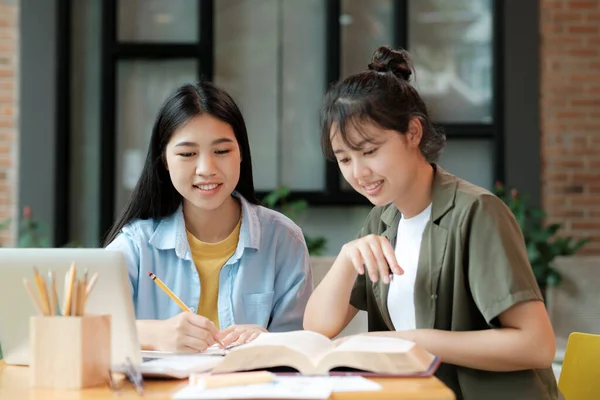 两个年轻女子在为考试或考试而学习 和朋友一起教书本 年轻学生的校园帮助朋友们迎头赶上和学习 — 图库照片