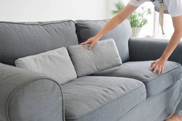 家事をしながら自宅のリビングルームでソファークッションを掃除 アレンジ 家事の概念 — ストック写真