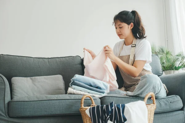 Junge Frau Faltet Kleidung Während Sie Hause Auf Dem Sofa — Stockfoto