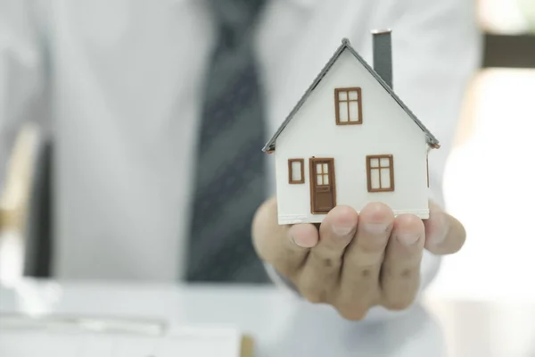 地产代理持有房屋模型和钥匙 与客户协商和讨论签订购买房屋保险协议的决策 房地产概念 — 图库照片