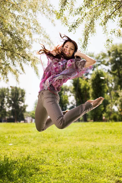 Mutlu genç kadın parkta atlama — Stok fotoğraf