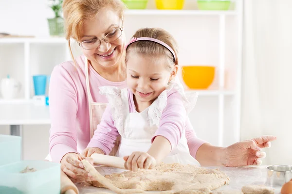 Grootmoeder en kleindochter maken deeg — Stockfoto