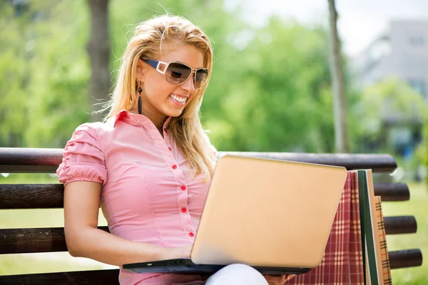 Young woman using laptop in the park — Stock Photo, Image