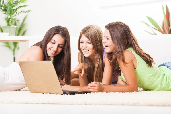 Drei fröhliche Freunde mit Laptop — Stockfoto